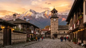 Старинната кула на църквата Св. Троица в Банско на фона на Пирин планина.