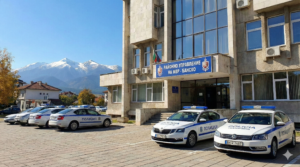 The Bansko Regional Police Department building and patrol cars against the backdrop of the Pirin Mountains