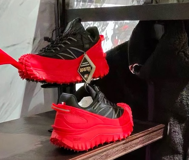 Черно-червени туристически маратонки с GORE-TEX мембрана, изложени на рафт в магазин