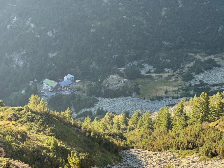 View from above of Vihren hut, located among coniferous forests and rocky slopes in Pirin Mountain.