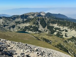 Panoramic view from above of a group of glacial lakes in the Pirin Mountain cirque, surrounded by rocky peaks