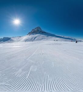 Панорамна гледка към слънчевите писти на Платото в Банско и връх Вихрен на заден план.