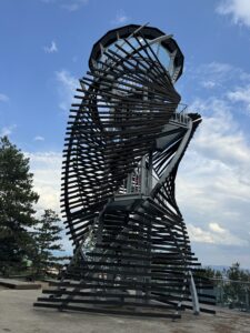 View of the wooden tower of the Stairs Panoramic Alley in Razlog with the Pirin Mountains in the background.