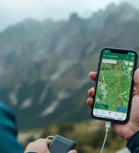 урист използва приложението AllTrails или Mapy.cz на телефон с топографска карта в мъглив ден в Пирин.