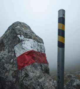 Лятна лентова маркировка на камък и зимен метален кол (жалон) в Пирин планина.