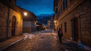Illuminated winter street in the old town of Bansko at night with a view of Pirin Mountain