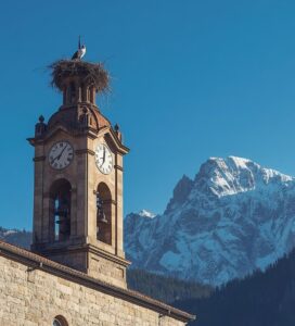 Камбанарията на църквата Света Троица в Банско на фона на Пирин планина