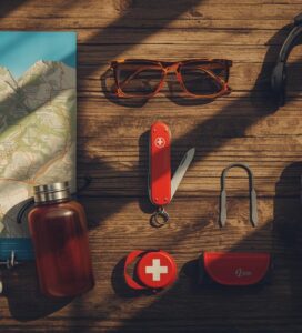 Екипировка за планина и 10-те най-важни неща за оцеляване подредени върху дървена маса