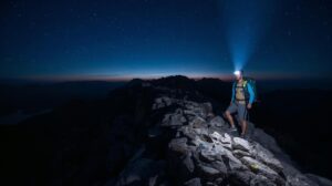 A hiker with a mountain headlamp illuminates a trail in Pirin at dusk