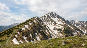 Panoramic view of the rocky Polejan peak in the Pirin Mountains under a cloudy sky.
