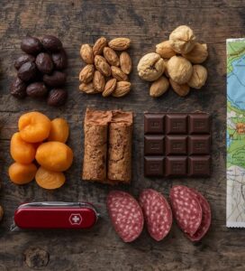 Разнообразна храна за планина - ядки, шоколад и луканка върху карта