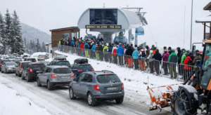 Snow-covered mountain road to the ski slopes in Bansko with a column of cars in winter.