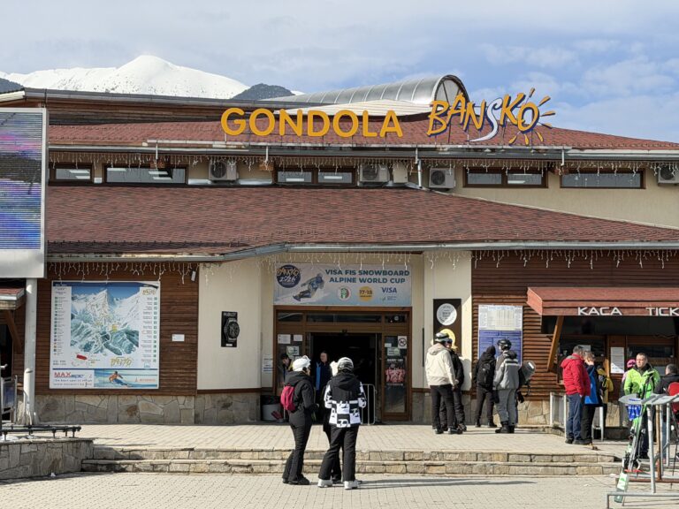 Скиори и хотелски микробуси пред началната станция на Гондолата в Банско през зимата