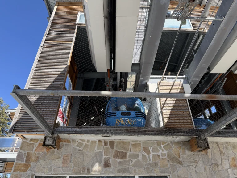 Кабинкова лифт станция в Банско с влизаща синя кабинка и детайл от стоманената конструкция.